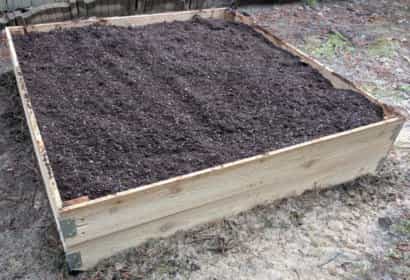 Full the raised bed with potting mix and spread evenly with a rake.