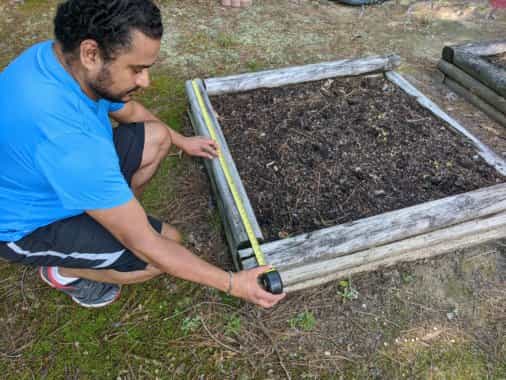 Measure the dimensions of each side of your garden bed using a tape measure 